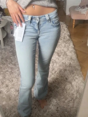 Ljusblåa low bootcut jeans - Säljer mina ljusblåa low bootcut jeans då storleken inte passade, de är oanvända endast provade och har lappen kvar🤍 Nypris 499. Storlek 32