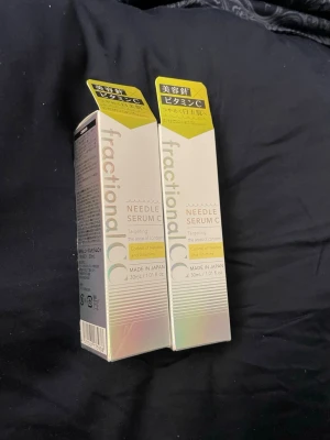 Fractional CC Needle Serum C x 2 - Två förpackningar av Fractional CC Needle Serum C, de är båda fortfarande förseglade och oöppnade. Det är ett ansiktsserum från Japan med vitamin C. Förpackningarna är vita med holografiska detaljer och gul etikett upptill. Innehåller 30 ml per flaska och är designade för hudvård.