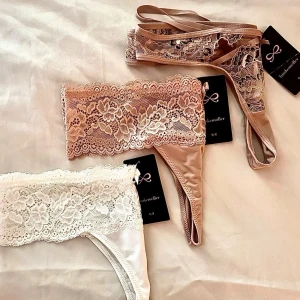 3x Hunkemöller stringtrosor NWT | Stl M - Paket med 3 par helt nya stringtrosor från Hunkemöller med prislappar kvar (nypris 149kr/st, värde 450kr).  Storlek M.  Supermjuk, stretchig spets. Modeller: 1. Wera String (Warm Taupe) - strappy design 2. Florence G-String (Rugby Tan) - bred spetskant 3. Florence G-String (Snow White) - vit spets Säljes som paket. ✨