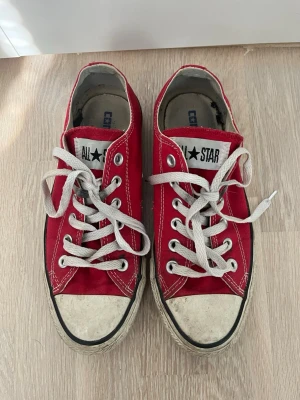 Röda Converse All Star låga sneakers - Klassiska röda Converse All Star sneakers med vit tå och vita snören. Skorna har lågt skaft och är tillverkade i canvas med gummisula. Storlek 37 ish 