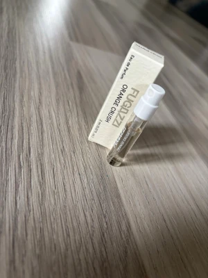 Fugazzi Orange Crush parfymprov - Litet parfymprov av Fugazzi Orange Crush, Eau de Parfum. Perfekt att testa en fräsch och citrusdoftande parfym innan du köper fullstorlek. TOP NOTES  Orange MIDDLE NOTES  White Amber BASE NOTES  Transparent Wood