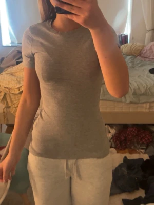 Grå tight t-shirt från Intimissimi - Säljer en enkel och stilren grå t-shirt från Intimissimi i Supima bomull. T-shirten har rund halsringning, korta ärmar och en tight passform som sitter snyggt på kroppen. Perfekt basplagg till garderoben! Ändast andvänd en gång.
