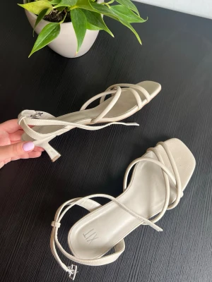 Beige strappy klackar från XIT - Ett par beiga klackar med spänne runt ankeln. Använt dom 2 gånger. Som ni ser har dem tappat lite färg på sidan på ena skon men det är inget som syns när du har på dig dem. Tror att klacken är 4cm. 150kr+61kr frakt🫶🏼