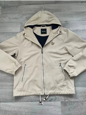 Beige vindjacka från Lyle & Scott - Väldigt stilig och skön jacka som passar både på vår/sommar/höst. Kostade 1650kr ny, har endast använt den 2 gånger men är inte riktigt min stil. Kan gå ner något i pris vid snabb affär. 