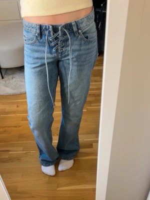 Ljusblå jeans med snörning fram - Säljer ett par ljusblå jeans med  snörning framtill. Använda max tre gånger, storlek 36 💕nypris 600!