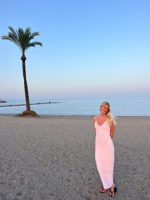 Ljusrosa långklänning med smala band - Säljer en ljusrosa långklänning med smala axelband och v-ringning. Köpt i en Butique i Marbella. Storlek L men skulle säga att den passar påse S och M. Jag är 180cm, så hyfsat lång modell.  Perfekt för sommarens alla tillfällen!🩷