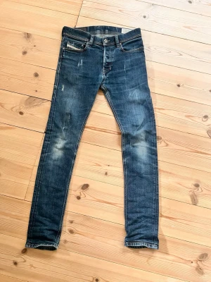Blå slitna skinny jeans - Säljer ett par blå skinny jeans med slitningar och tvättade detaljer. Materialet är klassisk denim. W28 L32