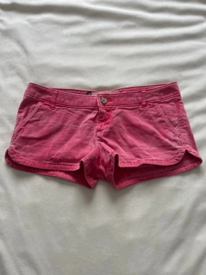 Lågmidjade jeansshorts  - Rosa lågmidjade jeansshorts ifrån Hollsiter, midjemåttet är 37cm! 
