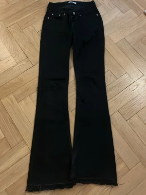 Svarta bootcut jeans från Perfect Jeans - Snygga svarta bootcut jeans från Perfect Jeans med klassisk femficksmodell och rå kant nertill. Jeansen är tillverkade i ett stretchigt denimtyg som sitter bekvämt. Perfekta för dig som gillar en retroinspirerad look.