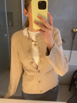 Beige kofta med rund hals - Snygg beige kofta med rund hals och knappar framtill. Koftan har två små fickor och ribbade muddar vid ärmslut och nederkant. Är helt oanvänd ❤️