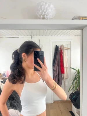 Vit croppad linnetopp - Vit topp med öppen rygg och justerbara snören. Aldrig använd, helt ny i skick. Bor i Danmark men skickar till alla länder.