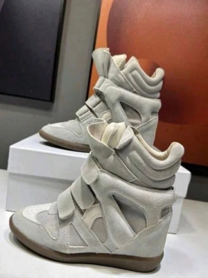 Isabel Marant Skor - Unika beige sneakers med högt skaft och flera breda kardborreband. Tillverkade i mocka med detaljer i textil och en brun gummisula. Skorna har en futuristisk design och vadderad häl för extra komfort. Perfekta för dig som vill sticka ut med din stil.