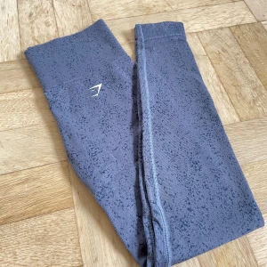 Gymshark tights adapt fleck evening blue S - Gymshark tights i modellen ”adapt fleck” i färgen evening blue. Skär inte in i midjan så de är väldigt sköna och inte genomskinliga. Sömmen på insida lår är lite sliten (se bild) men annars är dom i fint skick!