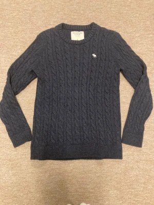 Abercrombie & Fitch - Abercrombie & Fitch kabelstickad tröja i mycket bra skick, tröjan är i storlek S och sitter mycket bra över en skjorta eller bara som den är, hör av er om frågor!