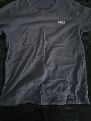 Svart t-shirt från Hugo Boss - Gammal hugo boss t-shirt som är mörk blå. Lite skrynklig men går att stryka så blir den som ny! Säljs billigt då jag rensar min garderob och vill bli av med kläder jag ej använder mig av längre