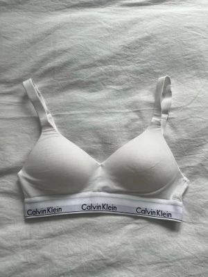 Vit Calvin Klein bh - Så snygg vit bh från Calvin Klein. Den här justerbara axelband och ett spänne där bak. Helt oanvänd, endast testad! Lappen är bortklippt. Storlek S, nypris 529kr💕