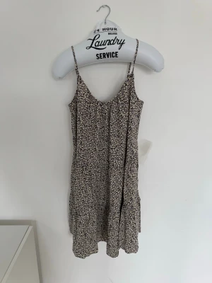 H&M - Blommig sommarklänning - Blommig kortklänning från H&M med tunna axelband och avslappnad passform.