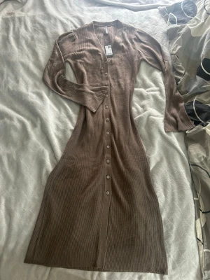 Brun ribbad långklänning med knappar - Brun lång klänning från lager 157, jättefin men kommer tyvärr inte till användning. Storlek xs. 