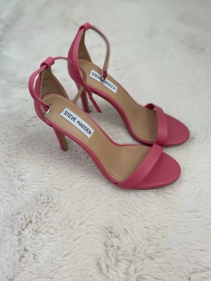 Klackskor Steve Madden  - Säljer ett par snygga rosa stilettklackar från Steve Madden med öppen tå och smal rem över foten. Klacken är 10,5 cm hög. Tyvärr passar de inte mig eftersom jag har storlek 38 och därför  endast använda för provning! 