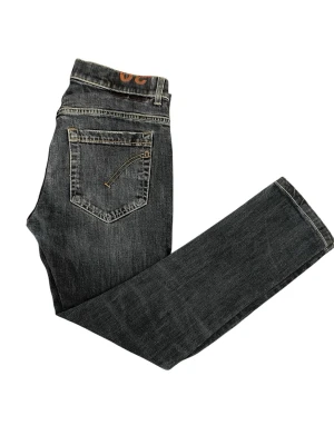 Mörkblå george jeans från Dondup Jeans - Snygga mörkblå jeans från Nudie Jeans med klassisk femficksmodell och kontrastsömmar. Jeansen har en rak passform och detaljerad bakficka med unik söm. Tillverkade i slitstark denim av bomull. Modellen är 167