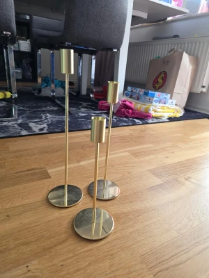 Ljusstake  - Ljusstake i guldimitation, ej haft stearinljus i dom, 