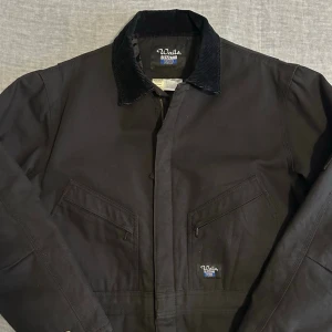 Vintage Walls Blizzard Pruf Duck Canvas Insulated Coveralls – Black Workwear Jumpsuit L - Vintage Walls Blizzard Pruf duck canvas insulated coveralls in heavyweight cotton canvas with quilted lining. Classic late 90s / early 2000s workwear piece with corduroy collar and utility pockets. Strong Carhartt alternative with real blue collar character. Relaxed insulated fit, perfect for winter layering or rugged Americana styling.  Waist 52 cm • P2P 64 cm • S2S 54 cm • Sleeve 61 cm • Full length 147 cm  Worn, not new – honest vintage condition. 