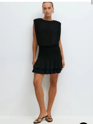 Svart kort klänning med volang - Säljer en helt oanvänd svart kort klänning med volang och rynkad midja. Klänningen har ärmlös design och en lös passform upptill, vilket ger en cool och avslappnad look. Perfekt för dig som gillar stilrena och trendiga plagg. Den är helt oanvänd och kommer med prislapp 