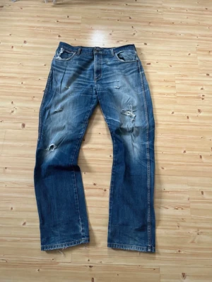 Vintage Wrangler jeans - Blåa distressed Wrangler jeans. W36 L34. Bra skick med coola detaljer. Modell på byxorna är texas 