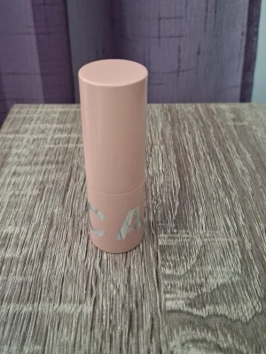 CAIA Läppstift, Splendour Series - Läppstift fån CAIA i nyansen Adore You som är en mjuk nude rosa ton, i en stilren, matt rosa hylsa och silvrig logga. Läppstiftet har en klassisk rundad form och ger en mjuk, naturlig färg till läpparna. Perfekt för dig som gillar en fräsch och enkel look.