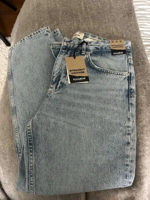  jeans Pull&Bear - Snygga ljusblå straight vintage jeans från Pull&Bear. Klassisk femficksmodell med hög midja och raka ben. Tillverkade i slitstark denim med en retro tvättad look. Perfekta för en avslappnad och trendig stil.