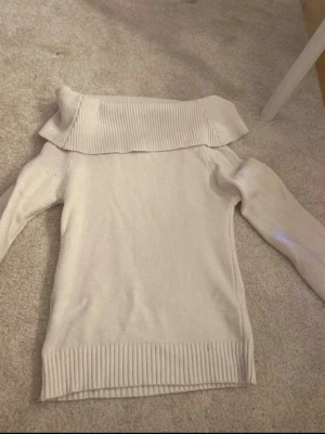 Vit off-shoulder stickad tröja XXS - Säljer en vit stickad tröja från 151 i storlek XXS. Tröjan har en bred, ribbstickad off-shoulder-krage och långa ärmar. Perfekt för dig som gillar en stilren och trendig look. Materialet är mjukt och bekvämt.