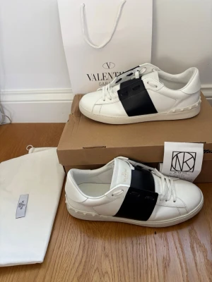 Valentino open vita sneakers med svart detalj  - Hej 👋 Skorna är ÄKTA‼️jag har kvitto. De har endast  använts någon enstaka gång och har inga defekter. Dustbag, valentino påse och kvittot ‼️ingår med skorna, men jag har tyvärr inte boxen kvar. Dock skickas skorna i en annan skolåda.