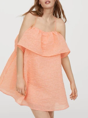Persikofärgad sommarklänning - Söt persikofärgad kort klänning med volang upptill och axelbandslös design. Klänningen har en lätt och luftig känsla, perfekt för varma sommardagar🥰🧡