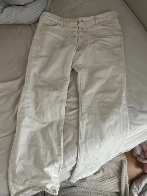 Vita jeans med snörning framtill - Dem har lite små fläckar här å var men inget som direkt syns som man inte kollar riktigt noga. Lite slitna nertill, annars fint skick. Köpte inte för alla längesen men pris går att diskutera💞