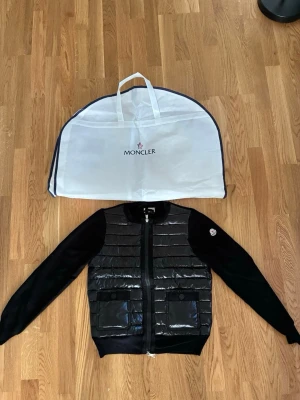 Moncler cardigan jacka - Säljer min helt nya och oanvända moncler cardigan i storlek 2 som motsvarar S/M  då den inte kommer till användning. Det finns en QR kod som garanterar äktheten och ett kvitto. Den säljes med alla sina tillbehör på bilden. 