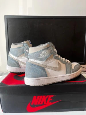 Nike Air Jordan 1 High Hyper Royal - Säljer mina Air Jordan 1 Hyper Royal i storlek 42. Skorna är lite använda men i väldigt bra skick – inga tydliga slitningar eller märken, ser nästan nya ut. Riktigt clean färg (ljusblå/vit/grå) som passar perfekt till sommaren Bekväma och enkla att matcha med outfits.  Säljes eftersom de inte riktigt är min stil längre.  Originalbox medföljer.                                                    Skriv vid intresse!