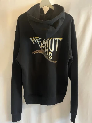Helmut Lang Hoodie  - Tja! Säljer nu denna svarta oversized hoodie från Helmut Lang. Den produceras ej längre.(2021 collection). Storlek M men skulle säga den passar L och även XL.  Skick 9/10  Ny pris: ca 7000kr  Säljs för: 1199kr Hör gärna av er vid frågor eller funderingar!