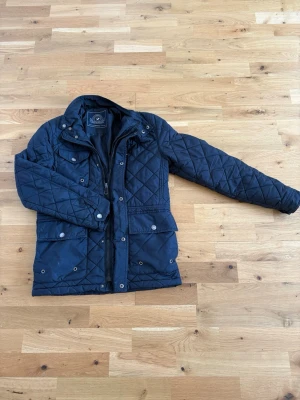 Mörkblå quiltad jacka Chaps & Friends - Snygg mörkblå quiltad jacka från Chaps & Friends med dragkedja och knappar framtill. Priset kan diskuteras. Skriv privat för fler bilder. Jackan e använd ett antal gånger men inga skador.