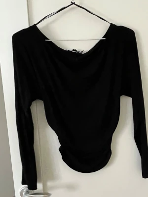 Svart långärmad topp från 157 - Svart långärmad topp från 157 med rund halsringning och figurnära passform. Enkel och stilren design som passar till många olika outfits. Perfekt basplagg för garderoben.