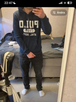 Mörkblå hoodie från Polo Ralph Lauren 1967 - Mörkblå hoodie med trycket Polo 1967 med vit tryckt logga och texten 'ATHL. DEPT.' på bröstet. Klassisk huva med dragsko och långa ärmar. Perfekt för en avslappnad och sportig stil.