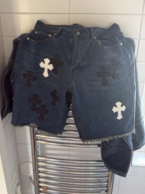 Chrome Hearts Jeansshorts - Säljer dessa chrome hearts jeansshorts då de inte passar mig längre. Midja 30. De är lite ljusare i verkligheten för att bilden togs när jag kom hem från regn.pris kan diskuteras!  Ni vet redan varför de är så billiga🙏