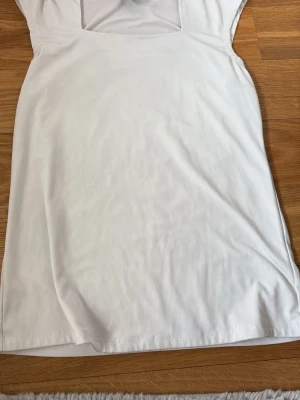 Vit topp från Grace i polyester - Säljer en enkel och stilren vit topp från Grace i stretchigt material. Toppen är ärmlös med en rak passform och har en mjuk känsla tack vare polyester och spandex. Perfekt att matcha med jeans eller kjol för en clean look.