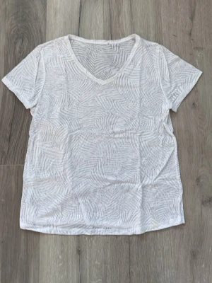 Tröja  - Vit tröja med mönster, OBS har ljusgula fläckar på två ställen, går kanske bort i tvätt.