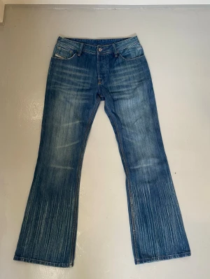 Vintage diesel bootcut jeans - Supersnygga vintage jeans från diesel som är bootcut och har en så snygg unik tvätt. Midja 40cm, innerbenslängd 81cm, benöppning 25cm.