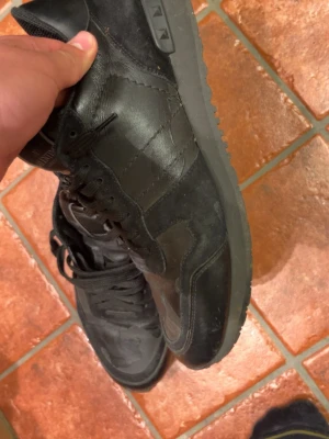 Valentino rockrunners för en varm och härlig känsla - Säljer ett par svarta valentinos. Skorna har en kombination av läder och mocka, med svarta skosnören och en robust yttersula. Perfekta för dig som gillar en stilren och tidlös look.