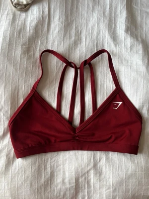 Vinröd gymshark sportbh  - Nypris 300kr, på gymsharks hemsida heter den ”Minimal Sports Bra”, men denna färg säljs inte längre. Knappt använd
