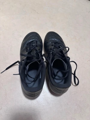Svarta fotbollsskor Adidas Copa - Säljer ett par svarta fotbollsskor med klassisk snörning och mönstrad ovandel. Skorna har en låg profil och är tillverkade i syntetmaterial med vadderad insida för extra komfort. Perfekta för dig som vill ha stilrena skor på planen.