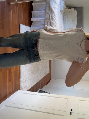 Vit spetsblus med volangärm - Superfin vit blus från pieces i spets med snygga volangärmar och rund halsringning. Blusen har ett vackert spetsmönster över hela plagget och är ärmlös med dekorativa kanter. (Priset går att diskutera)