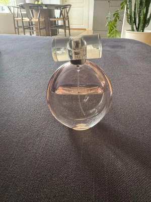 Calvin Klein Sheer Beauty parfym - Elegant parfym från Calvin Klein, Sheer Beauty, i en rund, transparent glasflaska med svagt rosa ton och silverfärgad spraykork. Flaskan har en modern och stilren design som känns lyxig och ungdomlig. 50 ml
