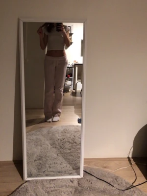 Ljusrosa mjukisbyxor med raka ben - Säljer ett par ljusrosa mjukisbyxor med raka ben och resår i midjan. Perfekt för chill dagar och har en enkel, clean look. Materialet ser ut att vara mjukt och bekvämt, troligtvis bomull eller polyesterblandning.